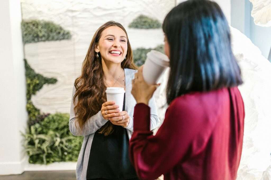 a woman holding a cup of coffee and smiling